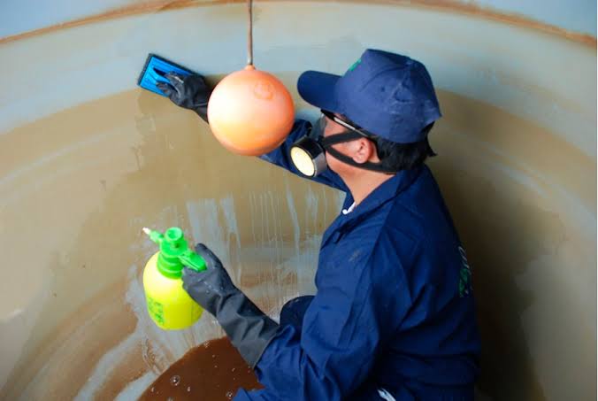 Técnico realizando la limpieza interna de un tanque de agua
